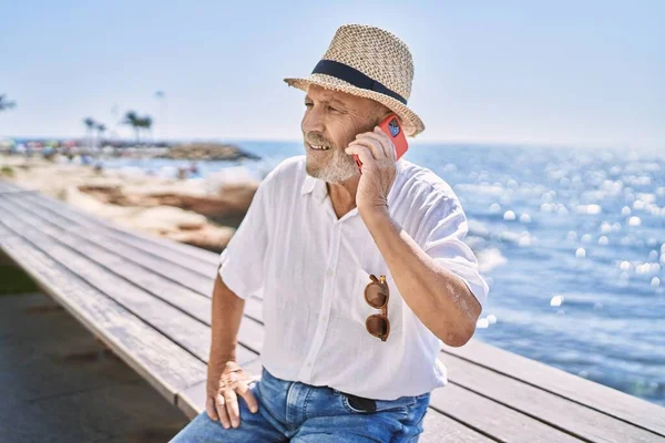 Senior Man Bär Sommarmössa Talar Smartphone Vid Havet — Stockfoto