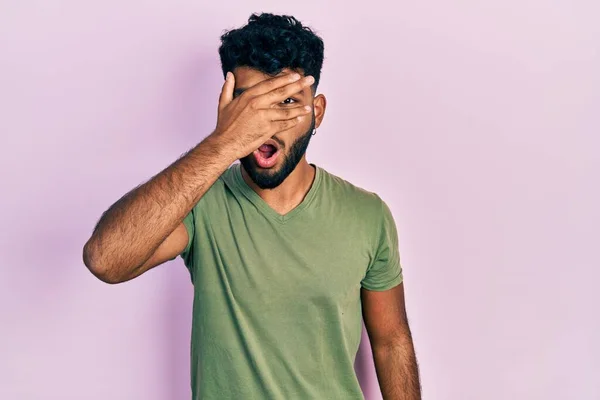 Homem Árabe Com Barba Vestindo Camisa Verde Casual Espreitando Choque — Fotografia de Stock