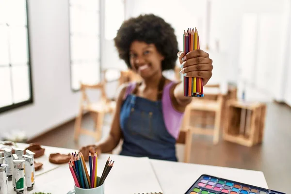 若いアフリカ系アメリカ人女性がアートスタジオで自信を持ってカラー鉛筆を保持笑顔 — ストック写真
