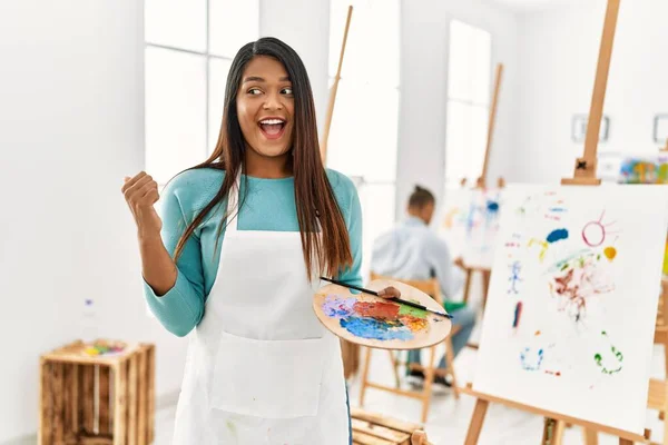 Young Latin Woman Standing Art Studio Pointing Thumb Side Smiling — Foto de Stock