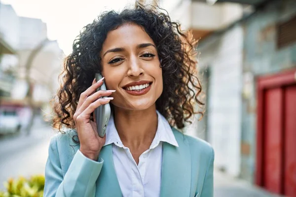 プロの笑顔を身に着けている若いヒスパニック系のビジネス女性は 電話で話す街で自信を持って笑顔 — ストック写真