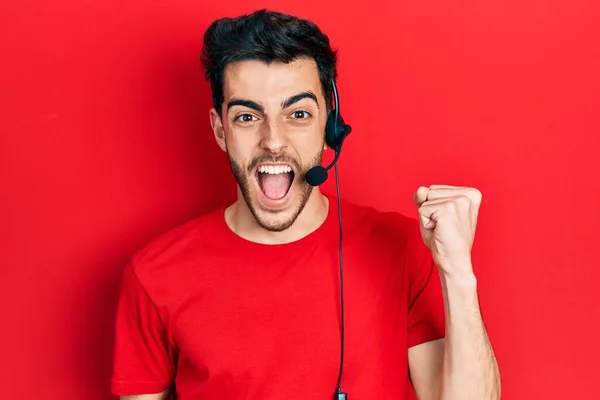 Young Hispanic Man Wearing Call Center Agent Headset Screaming Proud — Stock Photo, Image