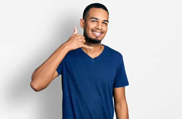 아프리카 미국인 남자가 가볍게 티셔츠를 손가락으로 통화를 것처럼 몸짓을 있습니다 — 스톡 사진