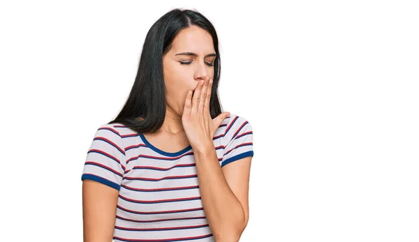 カジュアルなストライプのTシャツを着た若いヒスパニック系の女の子が手で口をカバー疲れあくび退屈 落ち着きもなく眠気もなく — ストック写真