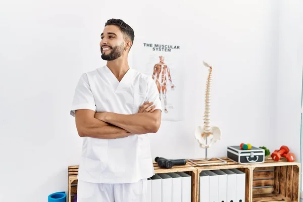 Junger Arabischer Mann Physiotherapeutenuniform Steht Mit Verschränkten Armen Klinik — Stockfoto