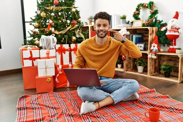 Arab Young Man Using Laptop Sitting Christmas Tree Pointing Hand — Foto de Stock