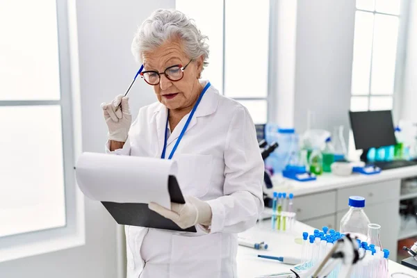 研究室では科学者の制服を着ているシニア白髪の女性 — ストック写真