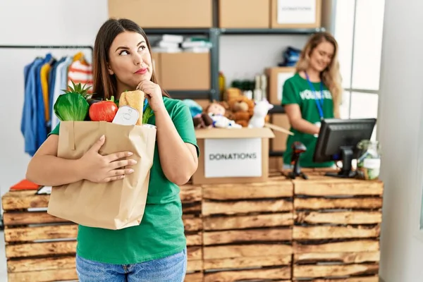 Young Brunette Woman Wearing Volunteer Shirt Holding Bag Food Serious — Stock Photo, Image