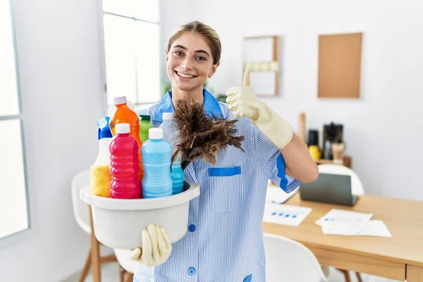 Young Blonde Woman Wearing Cleaner Uniform Holding Cleaning Products Doing —  Fotos de Stock