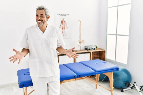 Middle Age Hispanic Therapist Man Working Pain Recovery Clinic Smiling — Stockfoto
