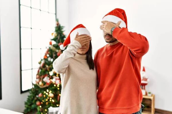 Jovem Casal Hispânico Junto Árvore Natal Cobrindo Olhos Com Mão — Fotografia de Stock