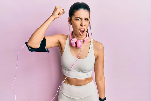 Young Hispanic Woman Wearing Gym Clothes Using Headphones Angry Mad — Stock Photo, Image