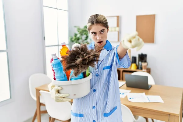Young Blonde Woman Wearing Cleaner Uniform Holding Cleaning Products Pointing — Stok fotoğraf
