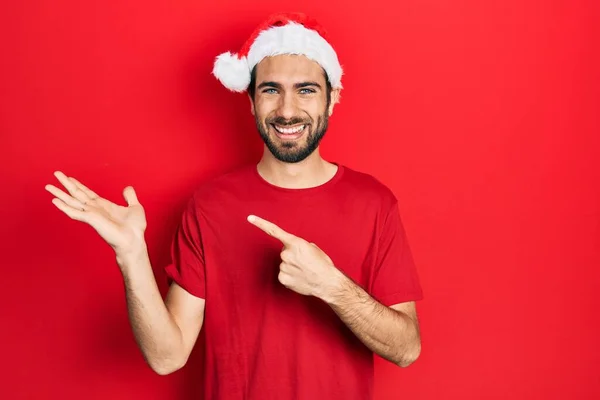 Jovem Hispânico Vestindo Chapéu Natal Maravilhado Sorrindo Para Câmera Enquanto — Fotografia de Stock