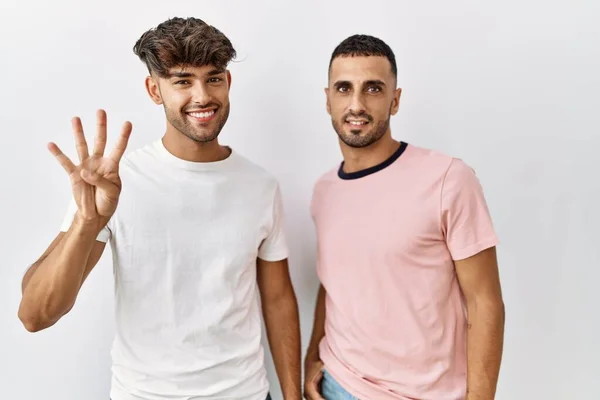 Young Gay Couple Standing Isolated Background Showing Pointing Fingers Number — Fotografia de Stock