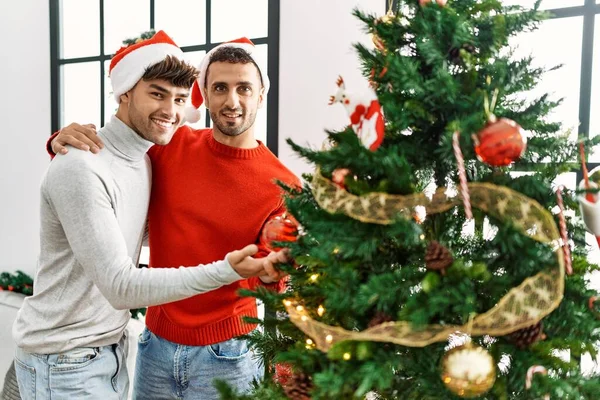 Two Hispanic Men Couple Hugging Each Other Decorating Christmas Tree — Fotografia de Stock