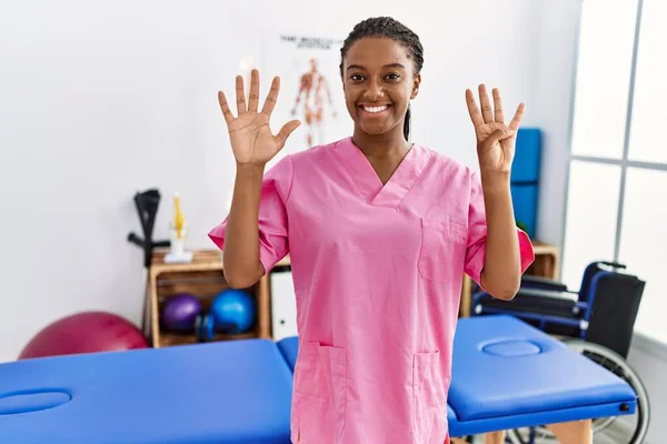 아프리카계 여성은 클리닉에서 자신감 행복하게 웃으면서 손가락 가리키며 일하고 있습니다 — 스톡 사진