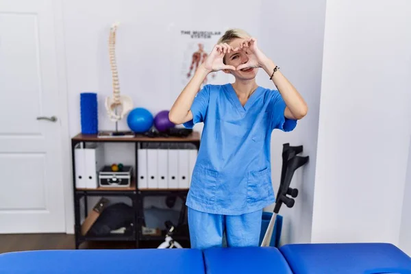 Young Physiotherapist Woman Working Pain Recovery Clinic Doing Heart Shape — Stockfoto
