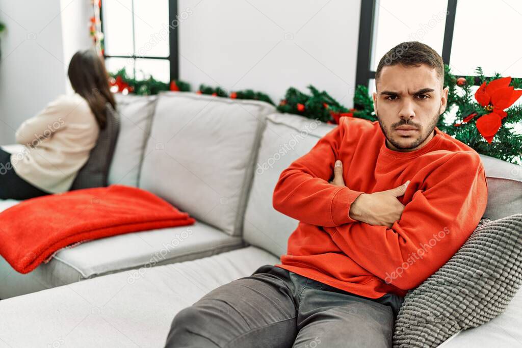 Young hispanic couple on problems with sad expression sitting on the sofa at home.