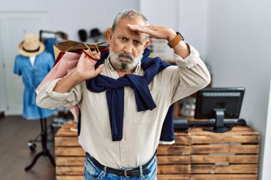 Butik dükkanında alışveriş torbaları tutan yakışıklı bir adam. Alnındaki bir sorun yüzünden endişeli ve stresli. Kriz için endişeli. 