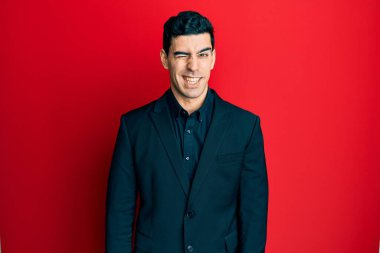 Yakışıklı İspanyol iş kıyafetleri giymiş, kameraya seksi bir ifadeyle bakıyor, neşeli ve mutlu bir yüzle.. 