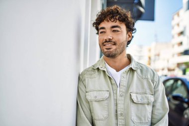 Yakışıklı, sakallı, güneşli bir günde mutlu bir şekilde gülümseyen bir İspanyol.