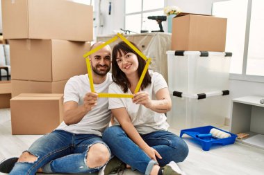 Genç İspanyol çift gülümsüyor mutlu ev projeleri yeni evinde tutuluyor.