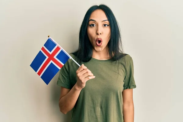 Chica Hispana Joven Sosteniendo Bandera Iceland Asustada Sorprendida Con Boca —  Fotos de Stock