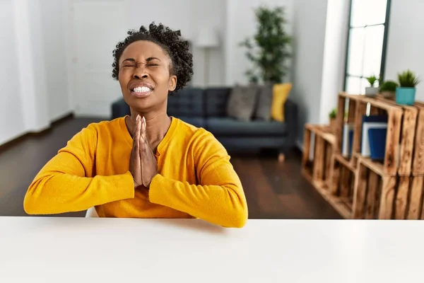 Młoda Afroamerykanka Ubrana Luźne Ubrania Siedząca Stole Domu Żebrząca Modląca — Zdjęcie stockowe