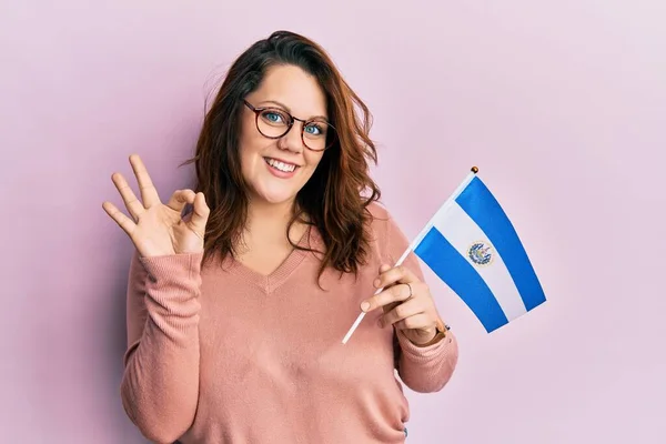 Young Caucasian Woman Holding Salvador Flag Doing Sign Fingers Smiling — Stockfoto