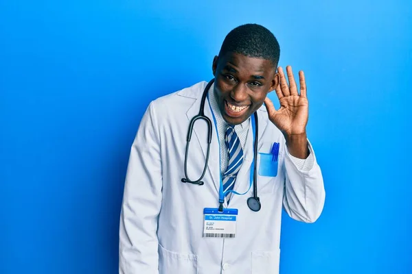 Young African American Man Wearing Doctor Uniform Smiling Hand Ear — Fotografia de Stock