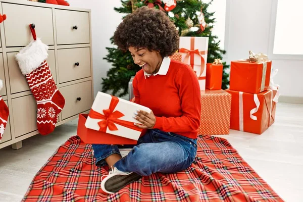 Young African American Woman Unboxing Gift Sitting Christmas Tree Home — ストック写真