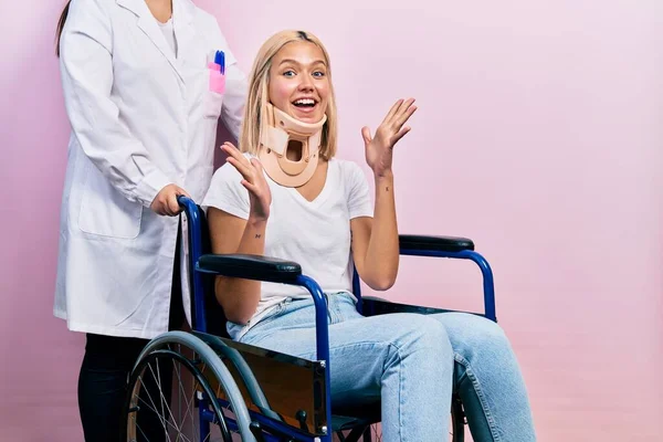 漂亮的金发女人坐在轮椅上 领着脖子 兴奋地欢呼着 兴奋地举起双臂 睁开眼睛 庆祝着成功 获奖者概念 — 图库照片