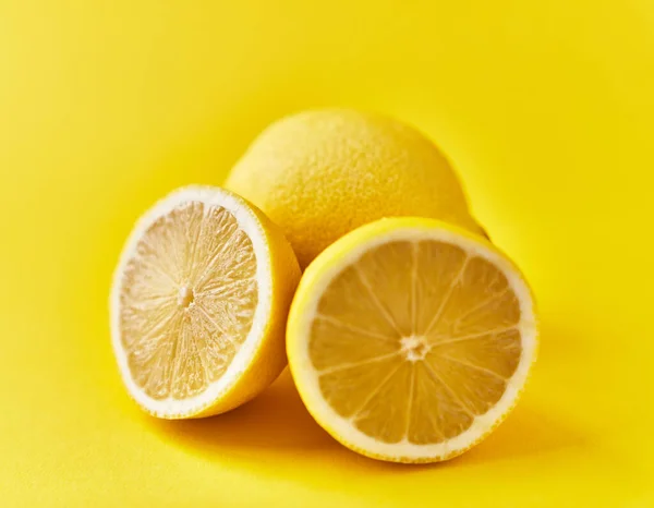 黄色背景下的单瓣柠檬和双瓣柠檬果 — 图库照片