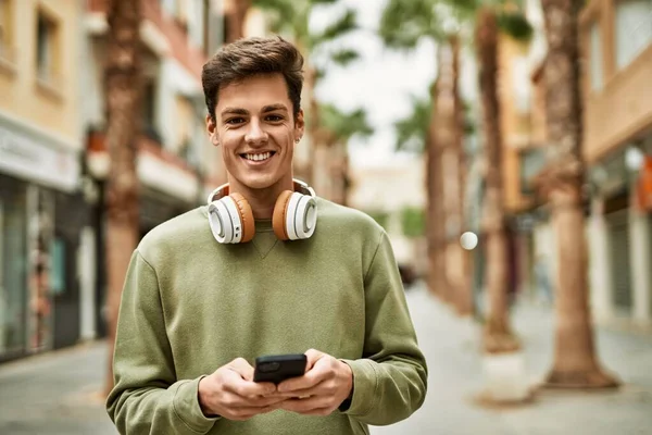 Joven Hombre Hispano Sonriendo Feliz Usando Teléfonos Inteligentes Auriculares Ciudad —  Fotos de Stock