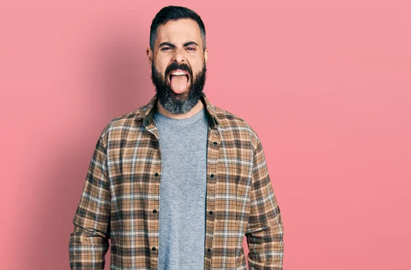 髭を生やしたヒスパニック系の男性が面白い表情で幸せ舌を突き出してカジュアルなシャツを着ています 感情の概念 — ストック写真