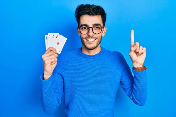 Young Hispanic Man Playing Poker Holding Cards Smiling Idea Question — Fotografia de Stock