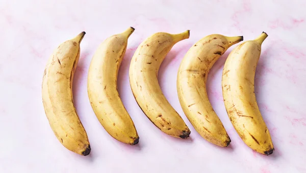 Група Бананів Рожевому Мармуровому Столі — стокове фото