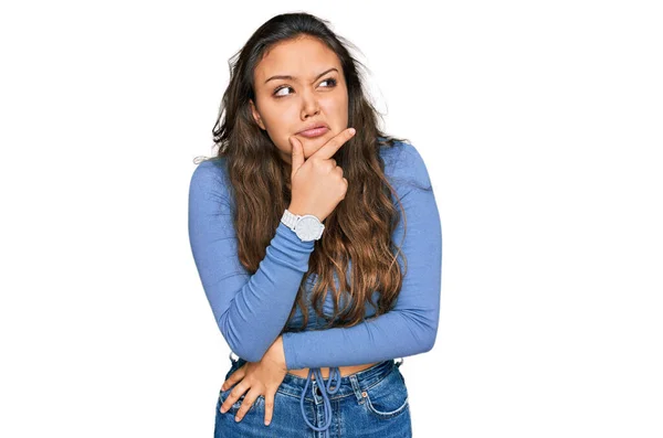 カジュアルな服を着ている若いヒスパニック系の女の子は 質問を心配し 心配し 顎に手で緊張 — ストック写真