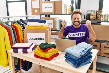 Gönüllü tişört giyen orta yaşlı bir adam başarılı olmak için heyecanlı kolları havada ve gözleri kapalı çalışırken zaferi kutluyor. Kazanan konsept. 