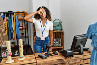 Güzel İspanyol kadın giyim mağazasında gülümsüyor. Mutluluktan gülümsüyor. El pençe divan duruyor. 