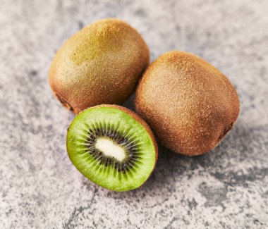  Bir avuç kivi ve beton bir yüzey üzerinde dilimler.