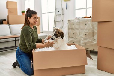 Evde köpekle oynarken kendine güvenen genç bir kadın.