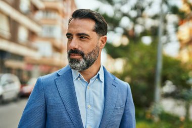 Şehirde duran rahat yüzlü orta yaşlı iş adamı..