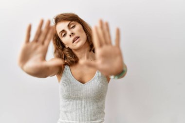 Güzel beyaz kadın izole arka planda duruyor. El ve parmakları kullanarak çerçeve yapıyor. Kamera bakış açısı. 