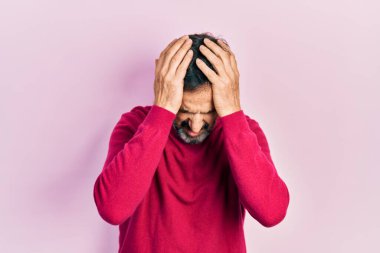 Orta yaşlı İspanyol bir adam gündelik kıyafetler giyiyor. Baş ağrısı çekiyor, çaresiz ve stresli. Çünkü acı ve migren ağrısı var. Eller başının üstünde.. 