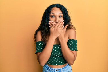 Gündelik kıyafet giyen genç Latin kadın yanlışlıkla ağzı ellerle kapatırken şok oldu. gizli kavram. 