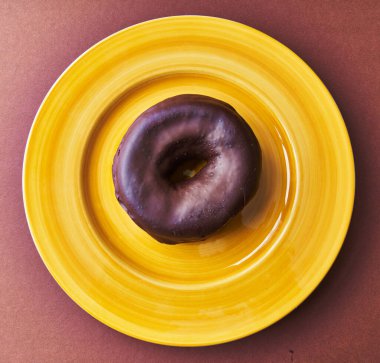  Kahverengi arka planda bir tabak çikolatalı çörek.