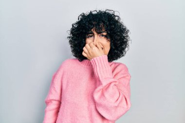 Orta Doğulu genç bir kadın günlük kıyafetler giyip pis ve iğrenç bir koku alıyor. Nefesini burnunda tutuyor. Kötü kokuyor. 