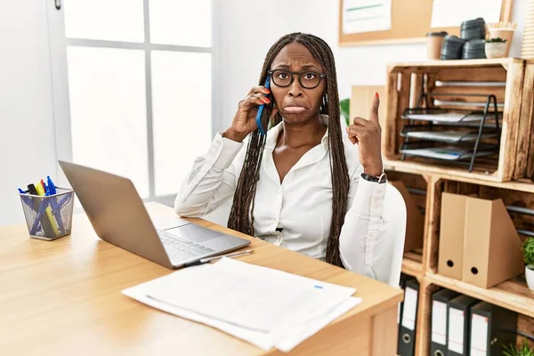 Mulher Negra Com Tranças Trabalhando Escritório Falando Telefone Apontando Para — Fotografia de Stock